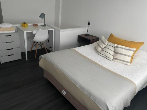 1 dormitorio con 1 cama con escritorio y silla en Montañeses 2830 Duplex Flat en Buenos Aires