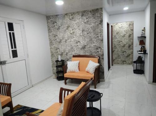a living room with a couch and chairs and a wall at ARNAS HOME in San Andrés
