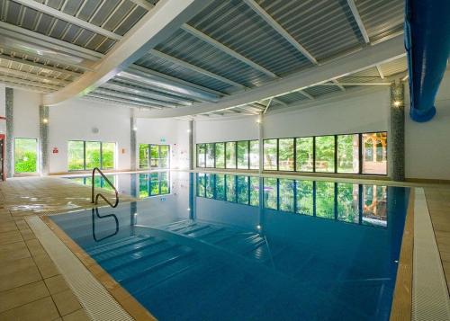a large swimming pool in a building with a swimming pool at Fell End in Milnthorpe