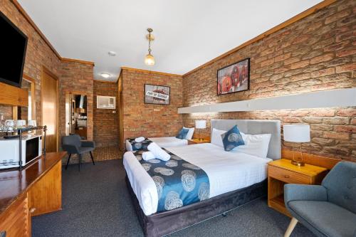a hotel room with a bed and a kitchen at The Settlement Historic Hotel in Echuca