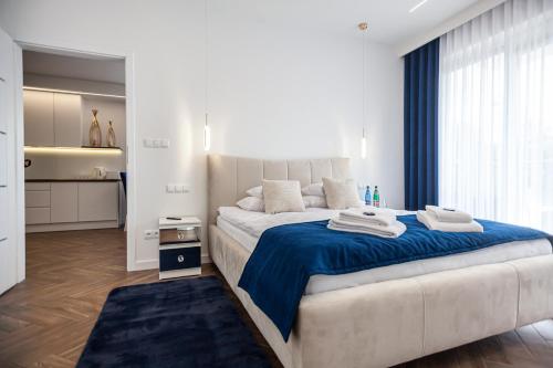 um quarto com uma cama grande e um cobertor azul em Apartament Leśny Taras & Garaż podziemny w cenie em Cedzyna
