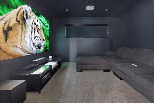 a living room with a couch and a big screen tv at 4 bedroom home with theatre room, close to CBD and beaches. in Sunshine Bay