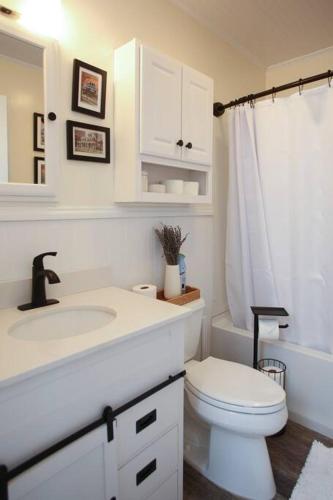 a white bathroom with a toilet and a sink at Cape May Classic Design that is Cozy, Elegant, and Inviting in Cape May