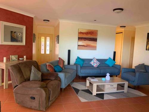a living room with two couches and a table at A picturesque 3 bedroom house with splendid views in Atherton