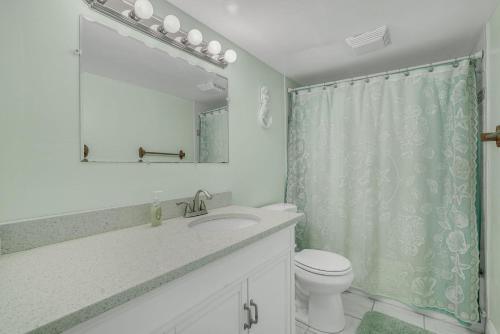 a bathroom with a sink and a toilet and a mirror at Oceana II 109 condo in Ocean City