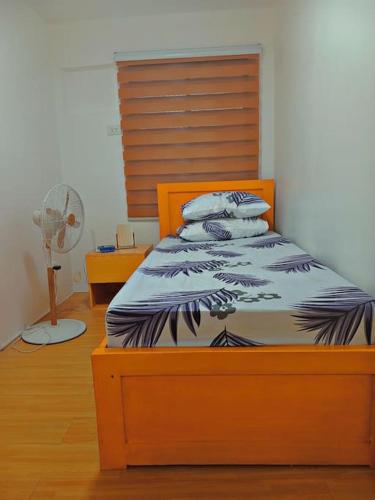 1 dormitorio con 1 cama y ventilador en Minamalist Condo Staycation en Imus