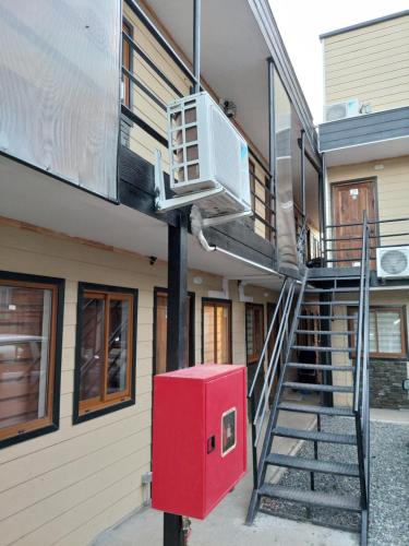 - un bâtiment avec une boîte rouge à côté d'un escalier dans l'établissement Cabañas Ases Loft Valdivia SIN ESTACIONAMIENTO, à Valdivia