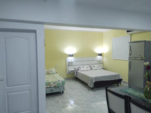 1 dormitorio con 2 camas, mesa y puerta en Cabañas Mundo al revés en La Silleta