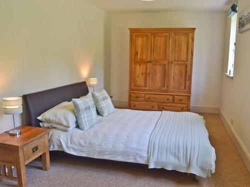 a bedroom with a bed and a wooden dresser at Pigeon Coo Farmhouse in Shalfleet