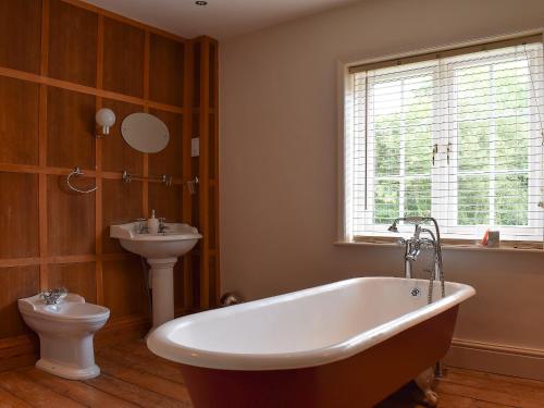 La salle de bains est pourvue d'une baignoire, de toilettes et d'un lavabo. dans l'établissement Pigeon Coo Farmhouse, à Shalfleet