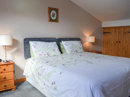 1 dormitorio con 1 cama blanca grande y 2 lámparas en Lakeland View en Scotforth