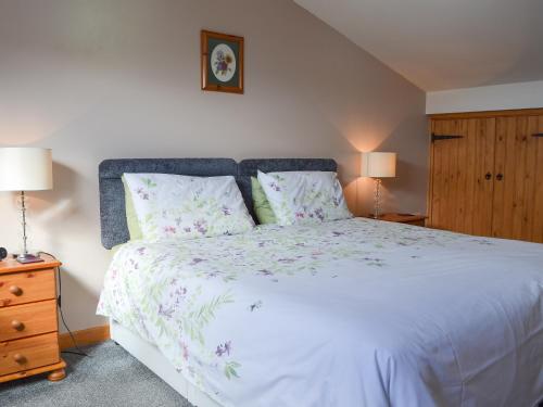 a bedroom with a large white bed with two lamps at Lakeland View in Scotforth