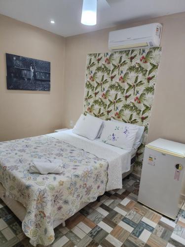 a small bedroom with a bed and a refrigerator at Pousada Miragem Do Mar Cabo Frio Praia Do Peró in Cabo Frio