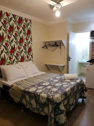 a bedroom with a bed with a floral wallpaper at Pousada Miragem Do Mar Cabo Frio Praia Do Peró in Cabo Frio