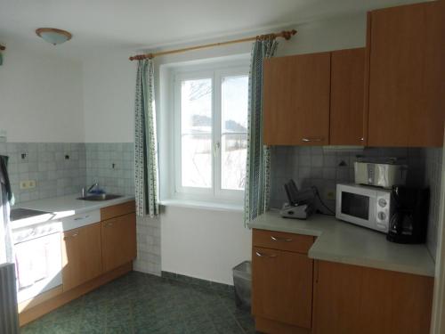 a kitchen with a microwave and a sink and a window at Ferienhaus Wohleser in Mariahof