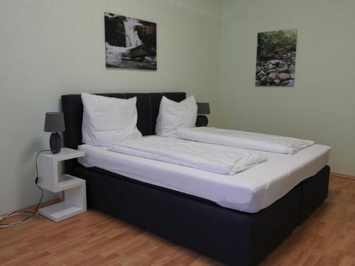 - un lit avec 2 oreillers blancs au-dessus dans l'établissement Apartment in the center of Ballenstedt, à Ballenstedt