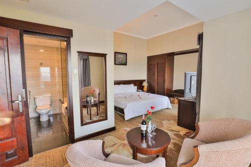 a hotel room with a bed and a bathroom at Saigon Quy Nhon Hotel in Quy Nhon