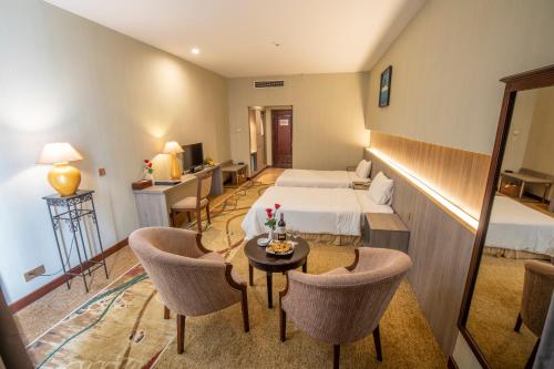 a hotel room with a bed and a table and chairs at Saigon Quy Nhon Hotel in Quy Nhon