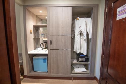 ein Schrank mit einer Tür mit einem weißen Hemd drauf in der Unterkunft Saigon Quy Nhon Hotel in Quy Nhon