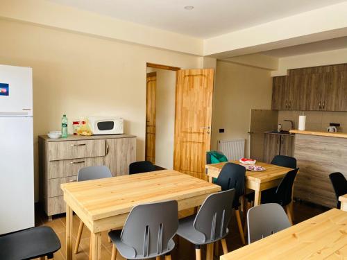 una cocina con mesas y sillas de madera en una habitación en House Near Forest, en Bakuriani