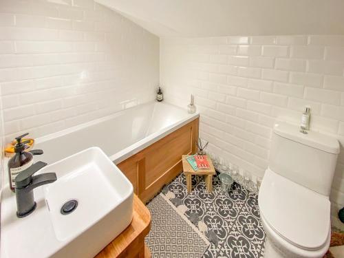 a bathroom with a sink and a tub and a toilet at Ivy Cottage in Metfield