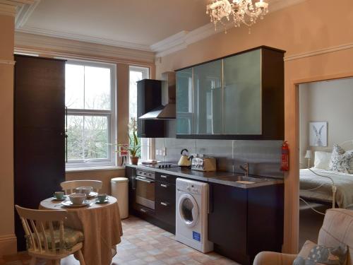 cocina con lavadora y secadora en una habitación en Broomleasowe House, en Whittington