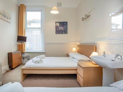 1 dormitorio con cama, lavabo y espejo en Apartment Three - Uk39836, en Paignton