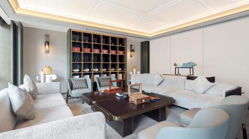 a living room with white couches and a table at HUALUXE Hotels and Resorts Qingdao Licang in Qingdao