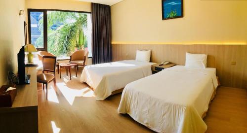 a hotel room with two beds and a window at Saigon Quy Nhon Hotel in Quy Nhon