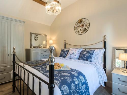 Un dormitorio con una cama azul y blanca y un espejo en Homestead Cottage en Benniworth