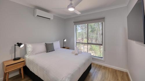 a white bedroom with a bed and a window at Tasman Holiday Parks - Moama on the Murray in Moama