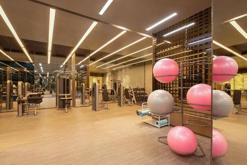 a gym with pink and white equipment in a room at HUALUXE Hotels and Resorts Qingdao Licang in Qingdao