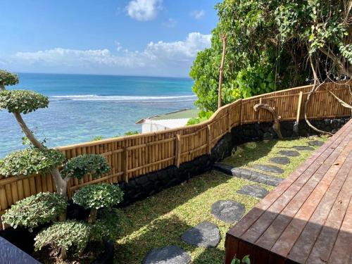 a wooden fence with the ocean in the background at The Hidden Escapes- Unique Tiny Home on Bingin Beach with Breathtaking Ocean & Sunset Views in Uluwatu