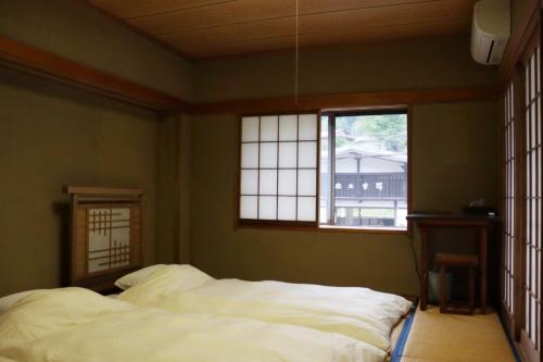 a bedroom with two white beds and a window at MOUNTAinn Nagiso in Nagiso