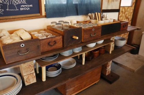 a counter with two wooden boxes with dishes and plates at MOUNTAinn Nagiso in Nagiso