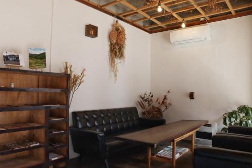 南木曾町的住宿－MOUNTAinn Nagiso，一间带桌子和真皮沙发的用餐室