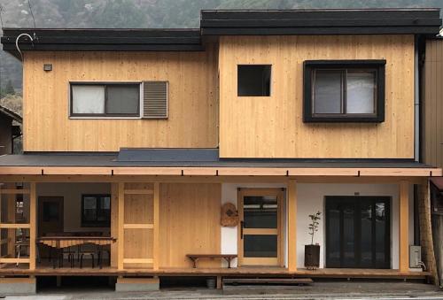 una casa de madera con una mesa delante en MOUNTAinn Nagiso en Nagiso