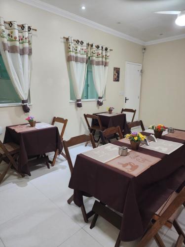 a dining room with tables and chairs and curtains at Pousada Miragem Do Mar Cabo Frio Praia Do Peró in Cabo Frio