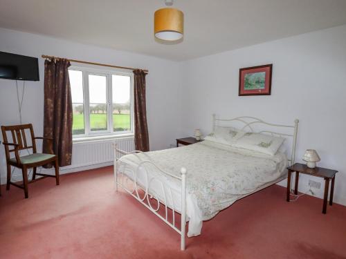 um quarto com uma cama branca e uma janela em The Manor House at Kenwick Lodge em Ellesmere