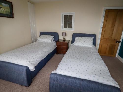 two beds sitting next to each other in a bedroom at The Manor House at Kenwick Lodge in Ellesmere
