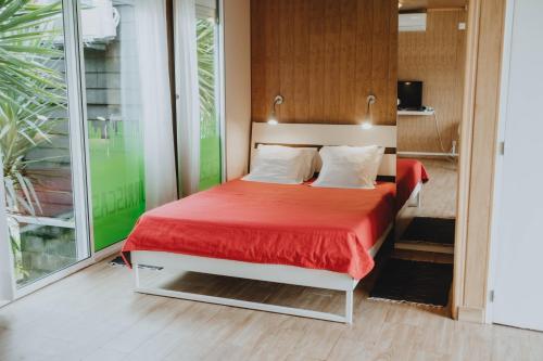a bedroom with a bed with a red blanket at Burriscas Campismo Rural in Montemor-o-Novo