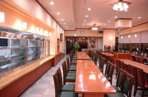 a dining room with long tables and chairs in a restaurant at Rinkai Hotel Kitamise in Sakai
