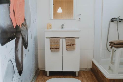 Un baño blanco con lavabo e inodoro. en Burriscas Campismo Rural, en Montemor-o-Novo