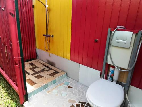a bathroom with a toilet and a colorful wall at TEREVAA 2 in Fare