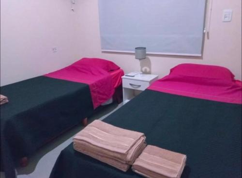 two beds in a room with pink and black at Pinares del Norte in Federación