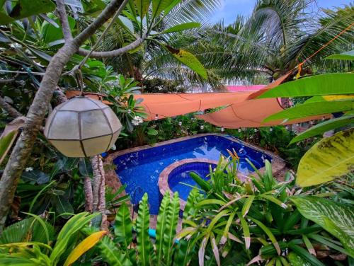 a resort with a swimming pool and a hammock at Tanaw sa Anilao Beach Resort in Mabini