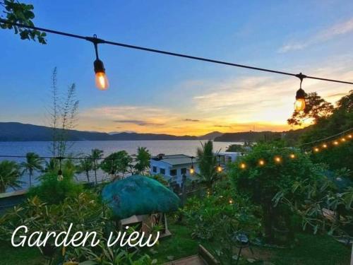 a garden view with lights hanging from a string at Tanaw sa Anilao Beach Resort in Mabini