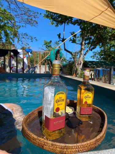 two bottles of alcohol on a tray next to a swimming pool at Tanaw sa Anilao Beach Resort in Mabini