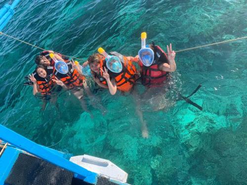 a group of people in the water on a boat at Tanaw sa Anilao Beach Resort in Mabini