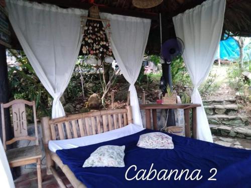 a bedroom with a blue bed with a canopy at Tanaw sa Anilao Beach Resort in Mabini
